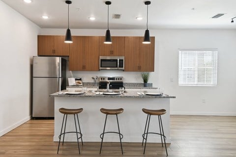 a kitchen with a island and three bar stools in front of a kitchen counter